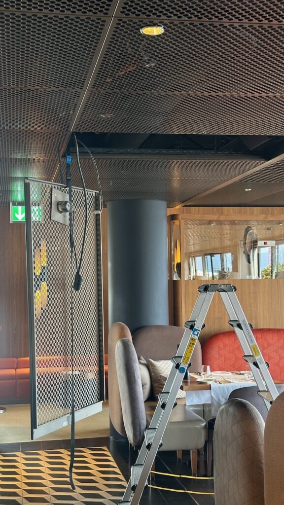 Das Deckengitter ist geöffnet, eine Leiter steht darunter