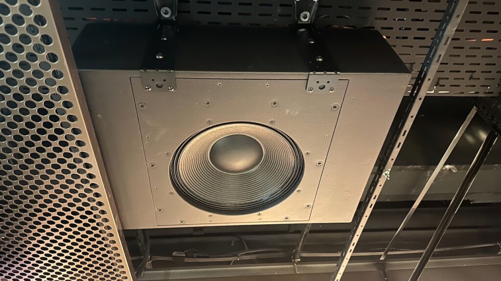 Oben ist ein Deckenbasslautsprecher über dem Gitter installiert